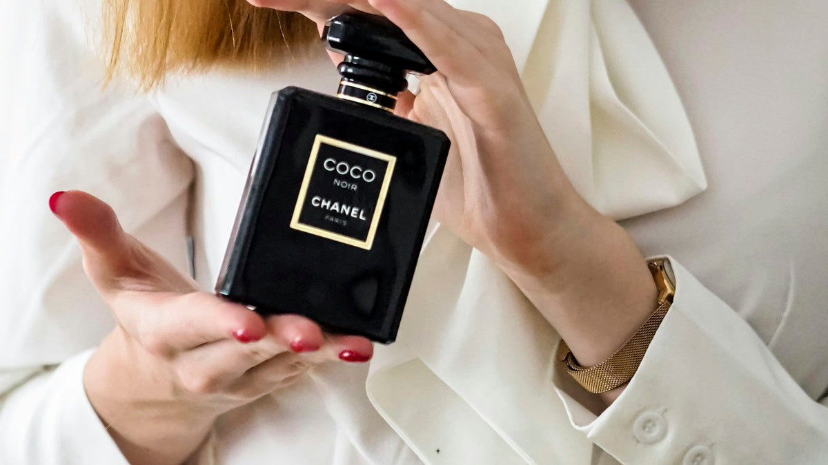 Detail rukou s flakonem Chanel Coco Noir při výběru parfému jako dárku